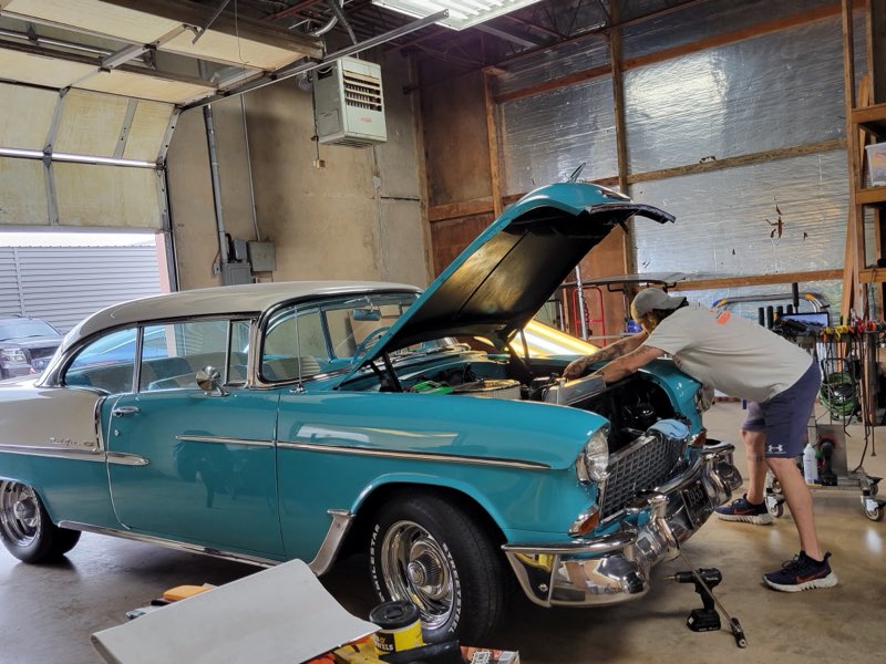 Classic teal Chevrolet Bel Air with the hood up inside PDR Plus Inc